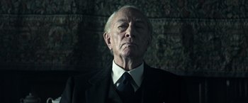 Movie still from “All the Money in the World” (2017), directed by Ridley Scott – An older man in a suit and tie; Close Up shot, Low angle