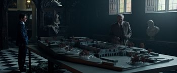 Movie still from “All the Money in the World” (2017), directed by Ridley Scott – A man sitting in front of a table with a model of a city; Extreme Wide shot, High angle
