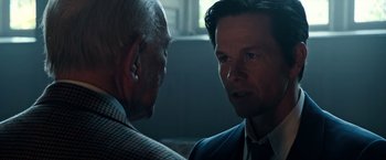 Movie still from “All the Money in the World” (2017), directed by Ridley Scott – A man in a suit talking to an older man in a suit; Close Up shot, Over the shoulder angle