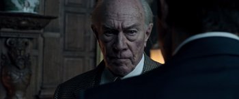 Movie still from “All the Money in the World” (2017), directed by Ridley Scott – An old man with a serious look on his face; Close Up shot, Over the shoulder angle
