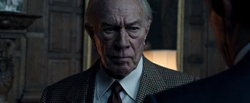 Movie still from “All the Money in the World” (2017), directed by Ridley Scott – An older man wearing a suit and tie; Close Up shot, Over the shoulder angle