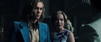 Movie still from “All the Money in the World” (2017), directed by Ridley Scott – A man and a woman standing next to each other; Medium shot, Low angle