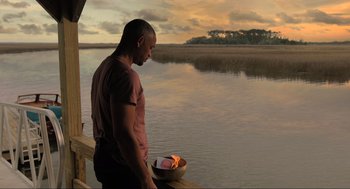 Movie still from “Gemini Man” (2019), directed by Ang Lee – A man standing next to a body of water; Wide shot, Over the shoulder angle