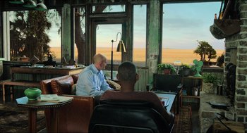 Movie still from “Gemini Man” (2019), directed by Ang Lee – Two men are sitting at a table in front of a window; Wide shot, Over the shoulder angle