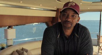 Movie still from “Gemini Man” (2019), directed by Ang Lee – A man in a baseball cap sitting in a car; Close Up shot, Over the shoulder angle