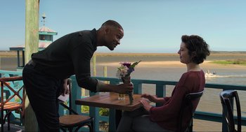 Movie still from “Gemini Man” (2019), directed by Ang Lee – A man and a woman sitting at an outdoor table; Medium shot, Over the shoulder angle