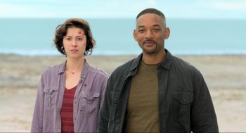 Movie still from “Gemini Man” (2019), directed by Ang Lee – A man and a woman standing next to each other on the beach; Medium shot, Low angle