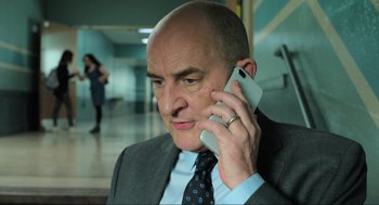 Movie still from “Gemini Man” (2019), directed by Ang Lee – A man in a suit and tie talking on a cell phone; Close Up shot, Low angle