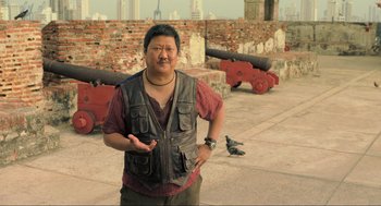 Movie still from “Gemini Man” (2019), directed by Ang Lee – A man standing in front of a wall with a pigeon; Medium shot, High angle