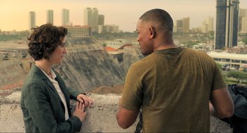 Movie still from “Gemini Man” (2019), directed by Ang Lee – A man and a woman holding hands in front of a city skyline; Medium shot, Over the shoulder angle