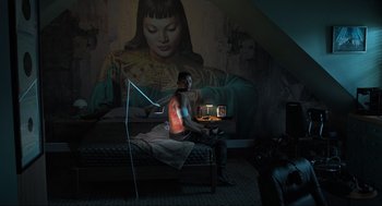 Movie still from “Gemini Man” (2019), directed by Ang Lee – A man sitting on top of a bed in front of a painting; Wide shot, Overhead angle