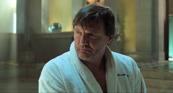 Movie still from “Gemini Man” (2019), directed by Ang Lee – A man in a white bathrobe sitting in front of a window; Close Up shot, Low angle