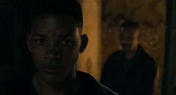 Movie still from “Gemini Man” (2019), directed by Ang Lee – Two men are standing in a dark room; Close Up shot, Over the shoulder angle