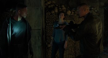 Movie still from “Gemini Man” (2019), directed by Ang Lee – A man filming two women in a dark room; Medium shot, Over the shoulder angle