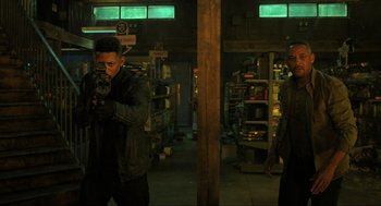 Movie still from “Gemini Man” (2019), directed by Ang Lee – Two men are standing in a warehouse holding guns; Medium shot, Low angle