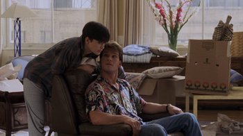 Movie still from “Ghost” (1990), directed by Jerry Zucker – A man sitting on a chair next to a woman; Medium shot, Over the shoulder angle