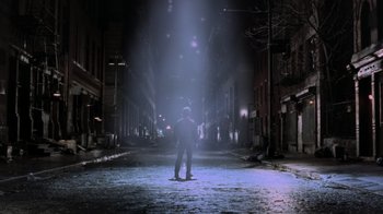 Movie still from “Ghost” (1990), directed by Jerry Zucker – A man standing in the middle of an empty street at night; Wide shot, Low angle