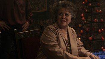 Movie still from “Ghost” (1990), directed by Jerry Zucker – An older woman sitting at a table in front of candles; Close Up shot, Over the shoulder angle