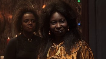 Two women standing next to each other in front of lights