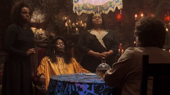 Movie still from “Ghost” (1990), directed by Jerry Zucker – Two women sitting at a table in a room; Medium shot, Over the shoulder angle