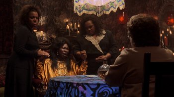 Movie still from “Ghost” (1990), directed by Jerry Zucker – A group of people sitting around a table; Medium shot, High angle