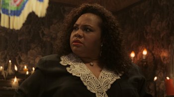 Movie still from “Ghost” (1990), directed by Jerry Zucker – A person with curly hair wearing a suit; Close Up shot, Over the shoulder angle