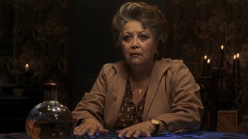 Movie still from “Ghost” (1990), directed by Jerry Zucker – An older woman sitting at a table in front of a clock; Close Up shot, Over the shoulder angle