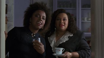 Movie still from “Ghost” (1990), directed by Jerry Zucker – A couple of women standing next to each other holding a cup; Close Up shot, Over the shoulder angle