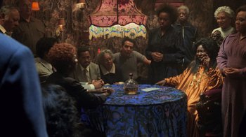 Movie still from “Ghost” (1990), directed by Jerry Zucker – A group of people sitting around a round table; Wide shot, Over the shoulder angle