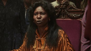 Movie still from “Ghost” (1990), directed by Jerry Zucker – A woman with long black hair wearing a gold dress; Close Up shot, Low angle