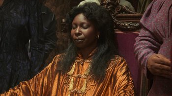 Movie still from “Ghost” (1990), directed by Jerry Zucker – An african american woman with long black hair wearing an orange dress; Close Up shot, High angle