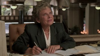Movie still from “Ghost” (1990), directed by Jerry Zucker – An older woman sitting at a table writing on a piece of paper; Close Up shot, Low angle