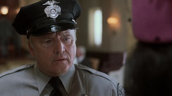 Movie still from “Ghost” (1990), directed by Jerry Zucker – A man in a police officer's uniform looks at the camera; Close Up shot, Low angle