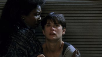 Movie still from “Ghost” (1990), directed by Jerry Zucker – A woman with short black hair is being hugged by another woman; Close Up shot, High angle