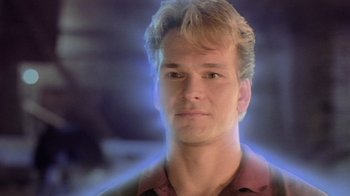 Movie still from “Ghost” (1990), directed by Jerry Zucker – A young man with blonde hair and a red shirt; Close Up shot, Over the shoulder angle