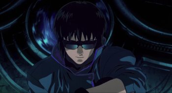 Movie still from “Ghost in the Shell” (1995), directed by Mamoru Oshii – A man wearing sunglasses and a black jacket; Close Up shot, Low angle