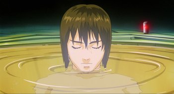 Movie still from “Ghost in the Shell” (1995), directed by Mamoru Oshii – A woman is sitting in a pool of water with her eyes closed; Close Up shot, High angle