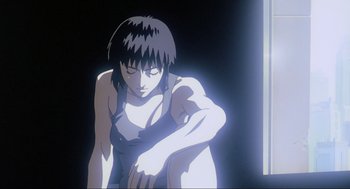 Movie still from “Ghost in the Shell” (1995), directed by Mamoru Oshii – A woman standing in the dark with her arms folded around her waist; Close Up shot, Low angle