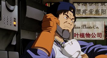 Movie still from “Ghost in the Shell” (1995), directed by Mamoru Oshii – An animated man holding a cell phone up to his ear; Close Up shot, Low angle