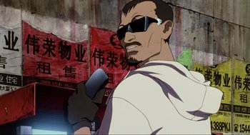 Movie still from “Ghost in the Shell” (1995), directed by Mamoru Oshii – A man with sunglasses is holding a cell phone; Close Up shot, Low angle