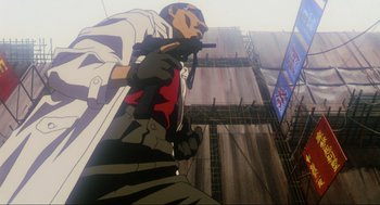 Movie still from “Ghost in the Shell” (1995), directed by Mamoru Oshii – An animated man is standing in front of a building; Medium shot, Low angle