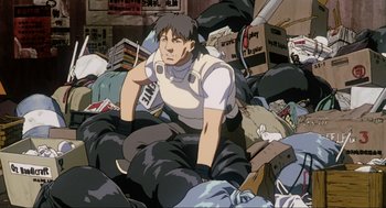 Movie still from “Ghost in the Shell” (1995), directed by Mamoru Oshii – A man sitting on top of a pile of garbage; Medium shot, Low angle