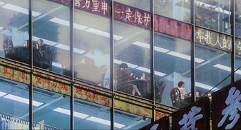 Movie still from “Ghost in the Shell” (1995), directed by Mamoru Oshii – A person sitting on a chair in front of a window; Extreme Wide shot, Low angle
