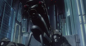 Movie still from “Ghost in the Shell” (1995), directed by Mamoru Oshii – A man sitting in front of a motorcycle in a city setting; Wide shot, Low angle
