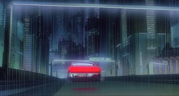 Movie still from “Ghost in the Shell” (1995), directed by Mamoru Oshii – A red car driving down a street in a city; Extreme Wide shot, Low angle