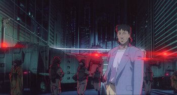 Movie still from “Ghost in the Shell” (1995), directed by Mamoru Oshii – An animated scene of a man in a suit and a red light; Medium shot, Low angle