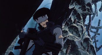 Movie still from “Ghost in the Shell” (1995), directed by Mamoru Oshii – An animated picture of a man with a gun in his hand; Medium shot, Low angle