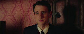 Movie still from “Ghostbusters” (2016), directed by Paul Feig – A person wearing a suit and tie; Close Up shot, Low angle