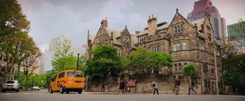 Movie still from “Ghostbusters” (2016), directed by Paul Feig – People walking on the sidewalk in front of an old building; Extreme Wide shot, Low angle