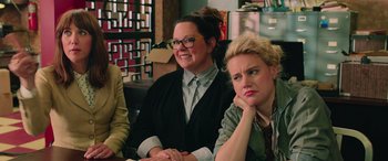 Movie still from “Ghostbusters” (2016), directed by Paul Feig – A couple of women sitting next to each other in a room; Close Up shot, Over the shoulder angle